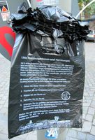 Hundekotbeutel mit Anleitung am Straßenschildmast in Hamburg