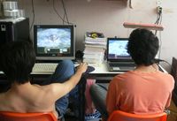 Zwei junge Männer spielen Computerspiele. (Thailand, 2007)