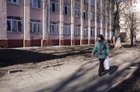 Eine Frau geht an einer Schule in Donezk vorbei, die beim Beschuss durch ukrainische Streitkräfte beschädigt wurde, 13. März 2023 Bild: Sergei Baturin / Sputnik