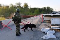 Ein Soldat des Innenministeriums der LVR überprüft mit einem Diensthund einen Kontrollpunkt im Gebiet Charkow auf Sprengstoff und Minen. Bild: Wiktor Antonjuk / Sputnik