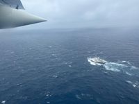 Eine HC-130 der US Coast Guard beim Überfliegen des französischen Forschungsschiffes L’Atalante