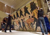 In der Aula der Universität Jena wird das großformatige Gemälde von Ferdinand Hodler abgehängt, bevor es restauriert und anschließend in der Bundeskunsthalle in Bonn ausgestellt wird. Quelle: Foto: Jan-Peter Kasper/FSU (idw)