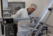 Prof. Weinheimer prüft im Reinraum ein hoch empfindliches Bauteil des Experiments "KATRIN". Foto: upm / Peter Grewer