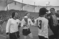 Jürgen Grabowski mit dem WM-Pokal nach dem Finalsieg bei der Weltmeisterschaft 1974. Zusammen mit Wolfgang Overath (links) und Gerd Müller (rechts) dreht er im Münchener Olympiastadion eine Ehrenrunde