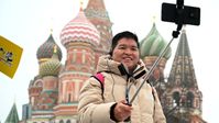 Ein Tourist aus China macht ein Selfie auf dem Roten Platz. Moskau, 24. Februar 2023. Bild: Sputnik / Ramil Sitdikov