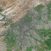 Satellitenaufnahme von Damaskus und Umgebung. Im Norden hebt sich der kahle Dschabal Qāsiyūn von den grünen Feldern der Ebene ab.