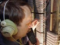 Ein Techniker hört Telefongespräche mit (gestelltes Foto)