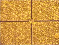 Bearbeitete und gereinigte Goldfolie des Detektors. Die Breite der Schnittlinien beträgt ca. 17 µm. Die einzelnen Foliensegmente werden an den jeweiligen Ecken zusammengehalten. Bild: PTB