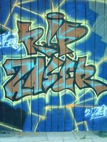 Übliches Graffito an einem Bauzaun