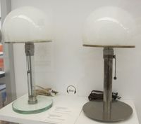 Die linke Leuchte ist eine 1923–24 entstandene Ausführung von Jucker, die rechte eine 1924 entstandene Ausführung von Wagenfeld