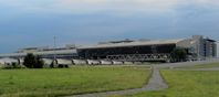 Check-in-Bereich (rechts) des Zentralterminals am Flughafen Leipzig/Halle, eröffnet 2003, davor der Flughafenbahnhof