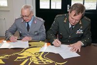 Oberst Burg Valk (re) und Oberst Henry Neumann unterzeichnen die Patenschaftsurkunde.