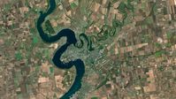 Farbiges Satellitenbild der Stadt Nikolajew. Das Dorf Nadbugskoje befindet sich etwa auf der Landzunge/Halbinsel, die von Westen in den Fluss Bug hineinreicht. Das vom Foto gezeigte Gebiet ist 50 km x 35 km groß, aufgenommen am 1. Oktober 2021 von Sentinel-2-Satelliten.