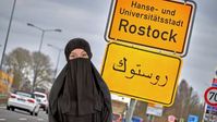 Islamisierung: Ortstafel der Hansestadt Rostock auf Arabisch.