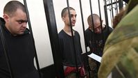 Die Briten Aiden Aslin and Shaun Pinner und der Marokkaner Saadun Brahim während der Gerichtsverhandlung in Donezk (Juni 2022)