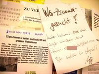 WG-Zimmer-Angebote und -Gesuche an einem schwarzen Brett in Berlin