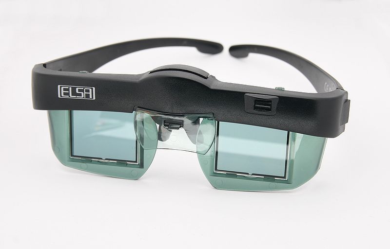 ELSA Revelator, IR-angesteuerte LCD-Shutterbrille für NVidia Grafikkarten. Über dem linken Auge ist der Empfänger für das IR-Synchronisationssignal zu erkennen, über dem Nasenbügel ist das Fach für die beiden Knopfzellen zur Stromversorgung zu sehen. Bild: Afrank99