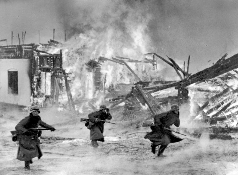 Wehrmachtssoldaten beim Kampf um ein brennendes Dorf